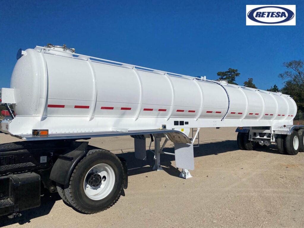 Large white tanker trailer for fuel or liquid transport, heavy-duty construction.