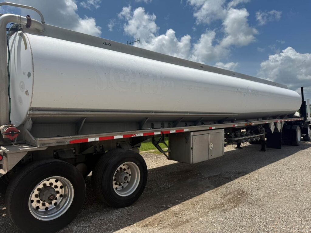 Large 9500-gallon fuel tanker trailer parked outdoors under a blue sky.